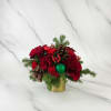 Red floral arrangement with pinecones and evergreen in a gold container