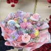 Pastel bouquet with pink roses, gerbera daisies, and a gingerbread decoration