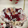 Bouquet of red roses with gingerbread decorations and candy accents