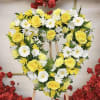Heart-shaped floral wreath with yellow roses and white daisies on an easel