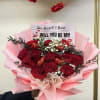 Bouquet of red roses with pink wrapping and a Valentine card