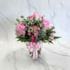 Pink mixed flower bouquet in a glass vase with a ribbon