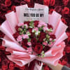 Bouquet of red roses and pink carnations wrapped in pink paper