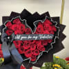 Heart-shaped bouquet of red roses with a black ribbon and Valentine message