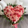 Heart-shaped bouquet of pink and red roses in a vase