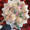 Pink bouquet with roses, ranunculus, and small daisies in white wrap