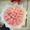 Bouquet of pink roses wrapped in pale paper with pearl trim