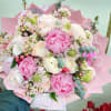 Pink and white bouquet with peonies and roses wrapped in pink paper