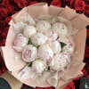 Bouquet of pale pink peonies wrapped in blush paper