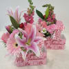 Pink floral gift boxes with lilies, roses, and a Valentine message