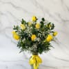 Yellow roses and baby's breath in a glass vase with a yellow ribbon