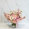 A delicate vase arrangement featuring a peach and white mini cymbidium orchid