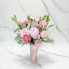Soft pink roses, carnations &amp; lisianthus with pale foliage in a decorated