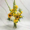 A bright arrangement featuring yellow sunflowers, roses, spray roses, and gladiolas, accented