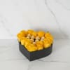 Heart-shaped box of yellow roses with chocolates in the center