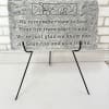 Gray memorial plaque on a black easel with engraved text