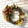 Autumn wreath with sunflowers, daisies, and a plaid bow
