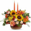 Teleflora's Fall's Harvest Centerpiece glows with radiant sunflowers, rich autumn blooms, and