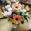 Bouquet of peach gerbera daisies and white roses in a clear glass vase
