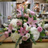 Pink lilies and white hydrangeas in a dark woven basket
