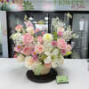 A soft, garden-style display of pink and white blooms makes this flower