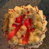Bouquet of cream roses wrapped with patterned paper and a red ribbon