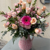 Pink and peach flower arrangement in a patterned vase