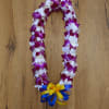 Purple and white orchid lei with blue and yellow ribbon bow