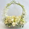 White floral basket arrangement with roses and orchids on an arched handle