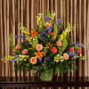 Large mixed flower arrangement in a green vase