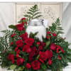 A dense cluster of red roses and red carnations crowns a classic