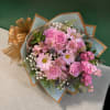 A fresh mix of pink roses and seasonal blooms, beautifully wrapped in