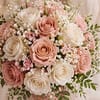 A romantic arrangement of blush pink and ivory roses with soft white