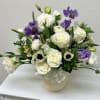 Soft white roses and delicate purple lisianthus come together in a serene