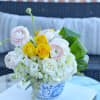 Bouquet of white, pink, and yellow flowers in a blue-and-white vase