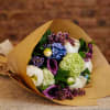 Bouquet of mixed flowers wrapped in brown paper