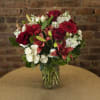 Red and white mixed flower bouquet in a glass vase