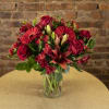 Red mixed flower bouquet in a clear glass vase