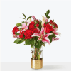 Red roses and pink lilies arranged in a clear vase with a gold base