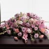The FTD Immorata Casket Spray offers soft beauty and blushing 
comfort to
