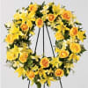 The FTD&reg; Ring of Friendship&trade; Wreath holds golden yellow roses, Asiatic lilies