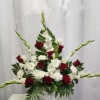 Red roses and white gladiolus arranged in a white vase