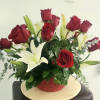 Red roses and white lilies in a red basket arrangement