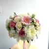 Pink and white mixed bouquet in a glass vase with a pink ribbon
