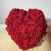 Heart-shaped arrangement of red roses held in a hand