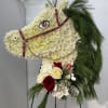 Horse-shaped floral standing spray with white blooms, red roses, and pine accents