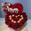Heart-shaped box of red roses with gold-wrapped chocolates and a ribbon bow