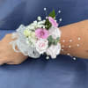 Pink and white wrist corsage with ribbon and pearl accents