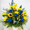 Blue and yellow mixed bouquet in a white container
