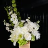 White floral arrangement in a wooden box with tall green spikes